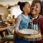 Photo of a mother and daughter holding a Thanksgiving pie